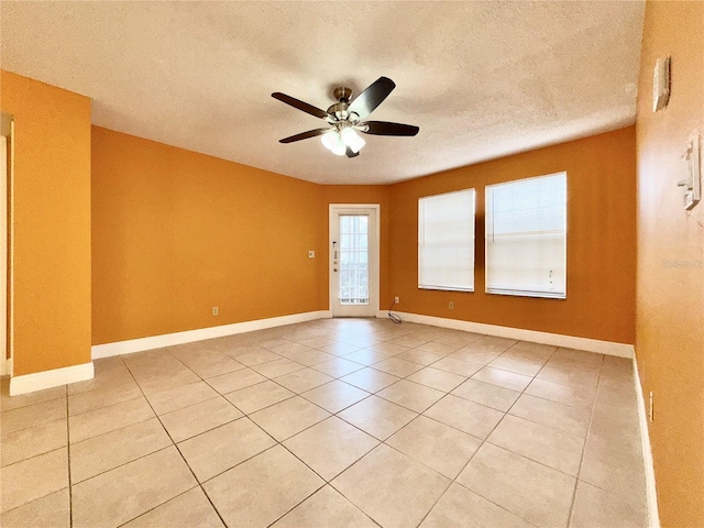 empty room with light tile patterned flooring, a textured ceiling, and ceiling fan