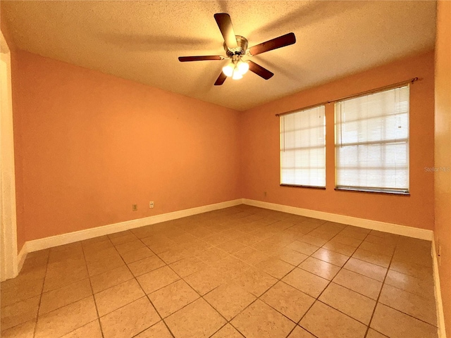 tiled spare room featuring a textured ceiling and ceiling fan