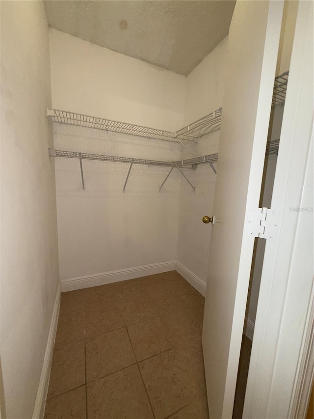 spacious closet featuring dark tile patterned floors