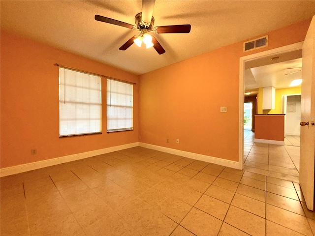 tiled empty room featuring ceiling fan and a textured ceiling