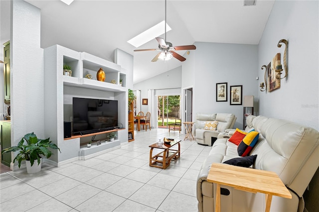 living room featuring a skylight, ceiling fan, light tile patterned floors, and high vaulted ceiling