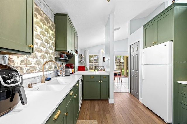 kitchen featuring light hardwood / wood-style floors, white refrigerator, green cabinets, and lofted ceiling