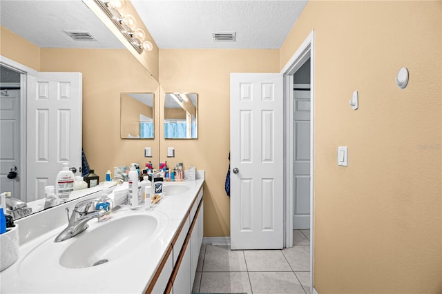 bathroom featuring a textured ceiling, vanity, and tile patterned floors