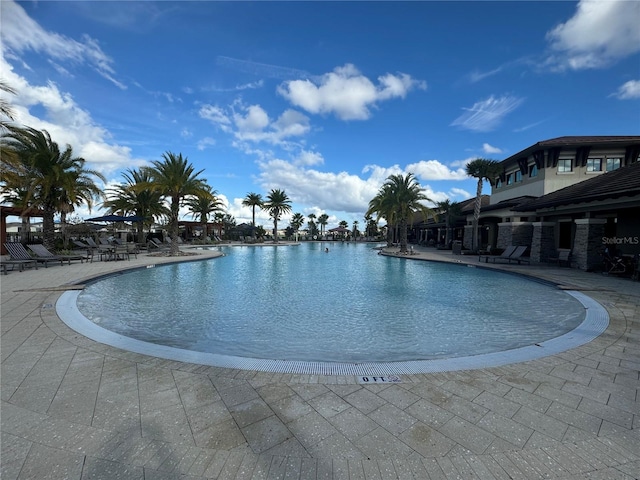 view of pool featuring a patio and a water view