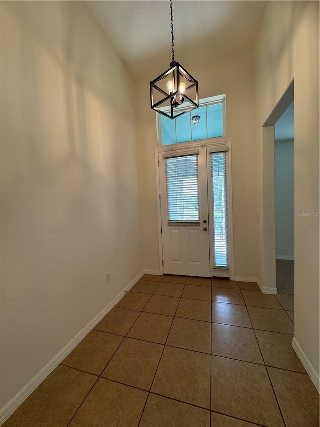 tiled foyer entrance with a chandelier