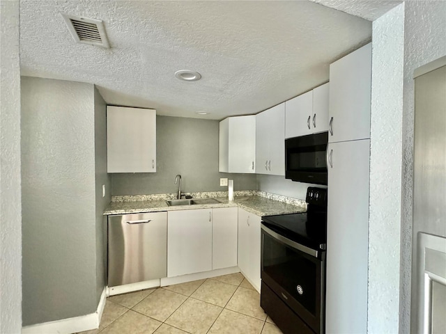 kitchen with black appliances, white cabinetry, sink, and a textured ceiling