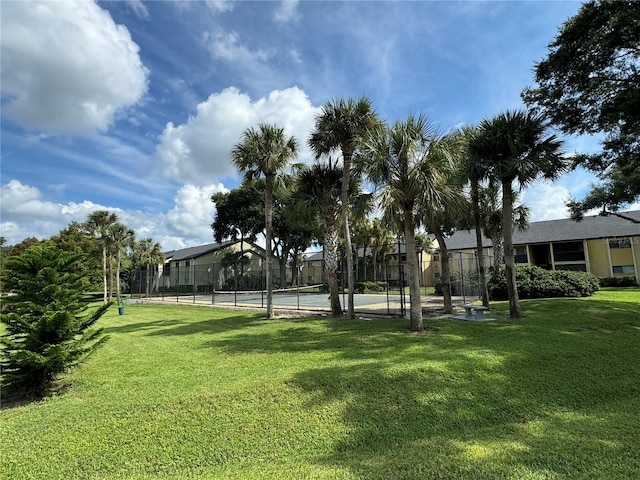 view of community with tennis court and a lawn