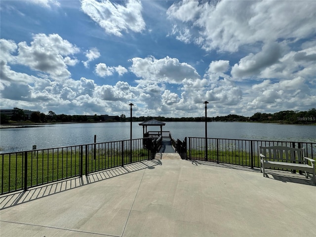 view of patio featuring a water view and a boat dock