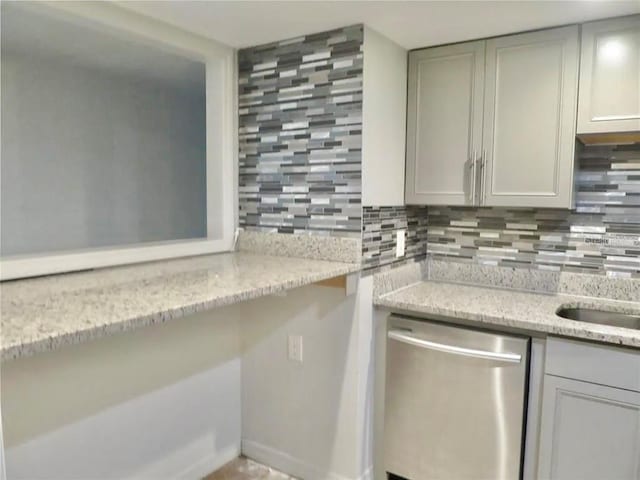 kitchen featuring stainless steel dishwasher, decorative backsplash, and light stone countertops