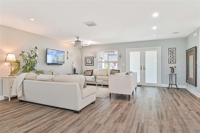 living room featuring ceiling fan, french doors, and light hardwood / wood-style flooring