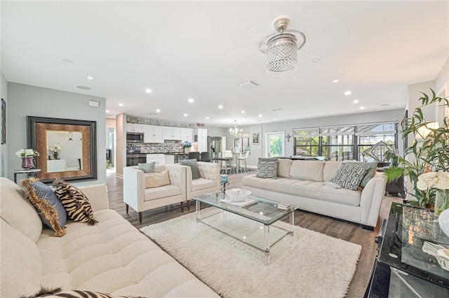 living room with dark hardwood / wood-style flooring and an inviting chandelier