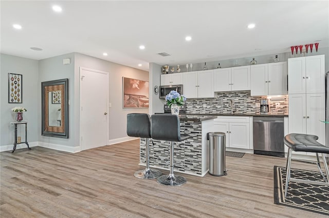 kitchen featuring light wood-type flooring, stainless steel appliances, and white cabinetry