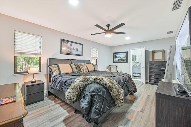 bedroom with wood-type flooring, ensuite bath, and ceiling fan