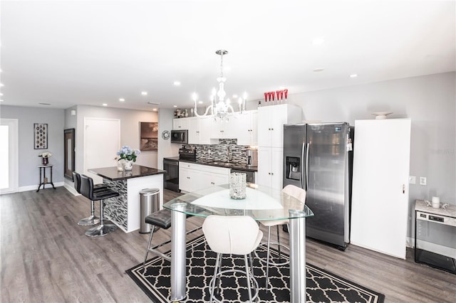 kitchen featuring a breakfast bar area, hanging light fixtures, appliances with stainless steel finishes, a kitchen island, and white cabinets