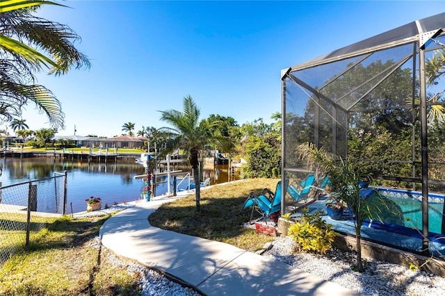 exterior space with a lanai, a dock, and a water view