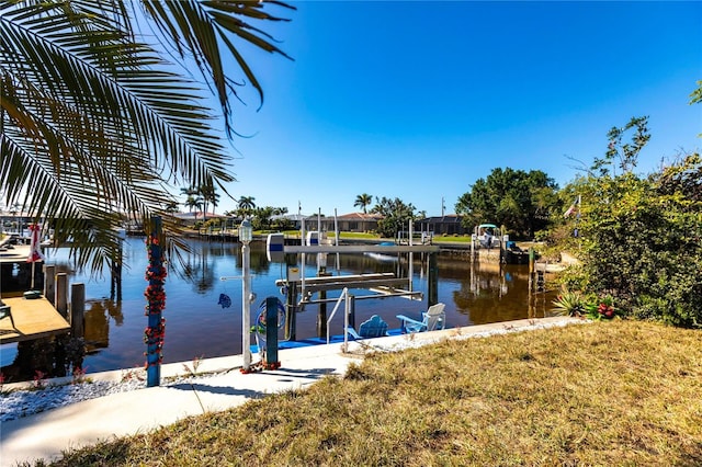 dock area with a water view and a lawn