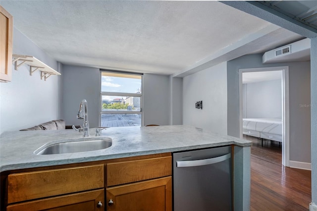 kitchen with a textured ceiling, dark hardwood / wood-style floors, stainless steel dishwasher, and sink