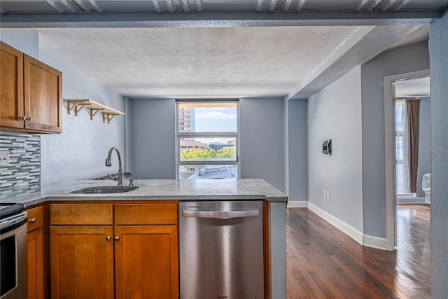 kitchen featuring dark wood-type flooring, sink, a textured ceiling, appliances with stainless steel finishes, and tasteful backsplash