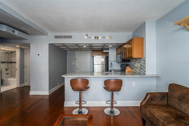 kitchen featuring kitchen peninsula, dark hardwood / wood-style flooring, stainless steel appliances, and sink