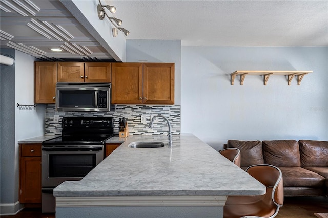 kitchen with a kitchen breakfast bar, tasteful backsplash, stainless steel appliances, sink, and dark hardwood / wood-style floors