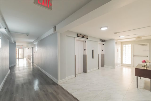 hall with elevator and hardwood / wood-style floors