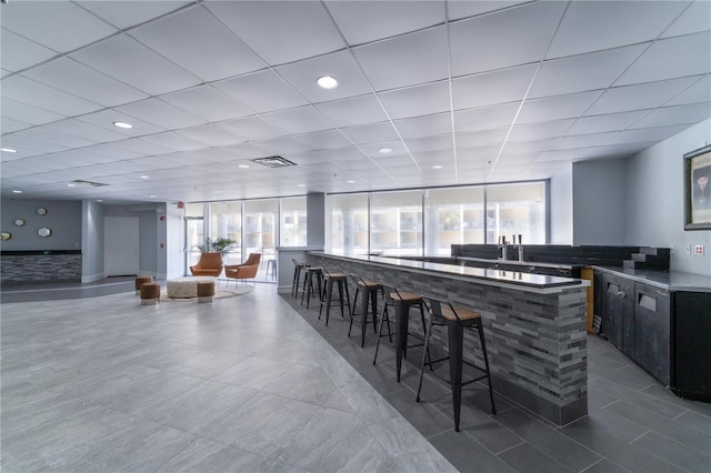 kitchen featuring a kitchen breakfast bar, a paneled ceiling, and tile patterned floors