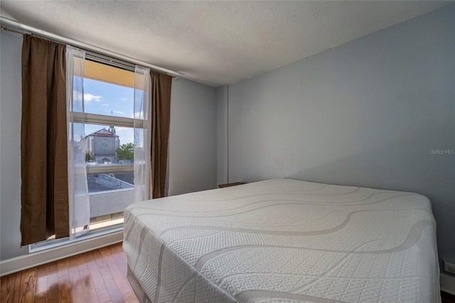 bedroom with hardwood / wood-style floors and a textured ceiling