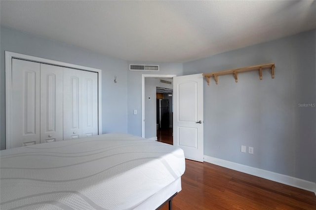 bedroom with a closet and dark wood-type flooring