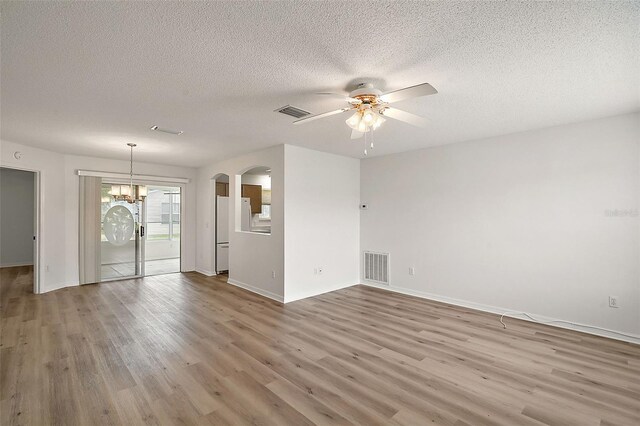 2788 Privada Dr, The Villages, FL 32162 - spare room with ceiling fan, wood finished floors, arched walkways, a textured ceiling, and a chandelier