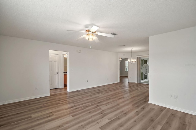 unfurnished room featuring a textured ceiling, hardwood / wood-style floors, and ceiling fan with notable chandelier