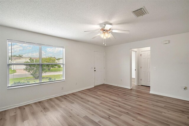 2788 Privada Dr, The Villages, FL 32162 - empty room featuring light wood-style flooring, a textured ceiling, ceiling fan, and baseboards