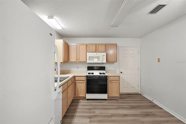 kitchen featuring light brown cabinets, white appliances, and light wood-type flooring