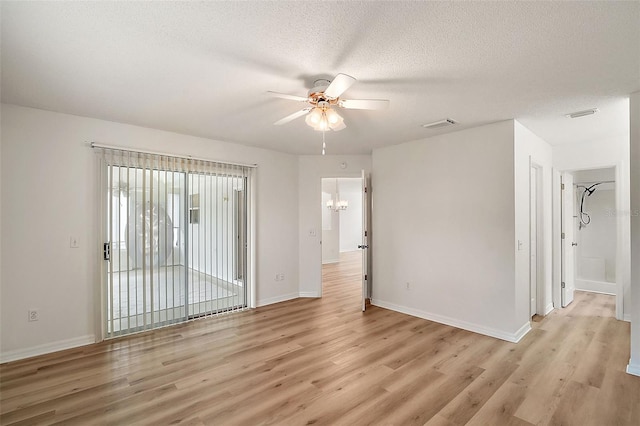 unfurnished room with light wood-type flooring, a textured ceiling, and ceiling fan with notable chandelier