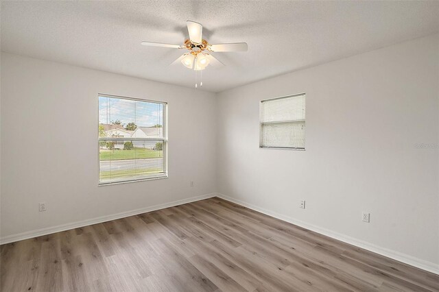 2788 Privada Dr, The Villages, FL 32162 - spare room with wood finished floors, a ceiling fan, baseboards, and a textured ceiling