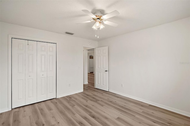 unfurnished bedroom with a closet, light wood-type flooring, and ceiling fan