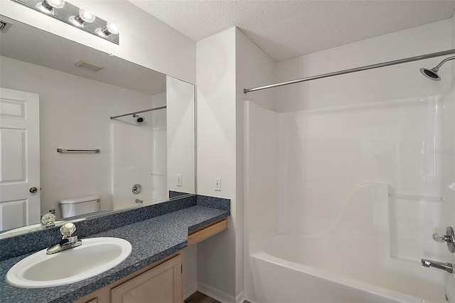 full bathroom featuring vanity, a textured ceiling, toilet, and  shower combination