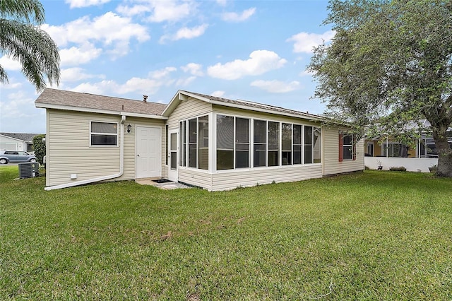 rear view of property with a sunroom and a yard