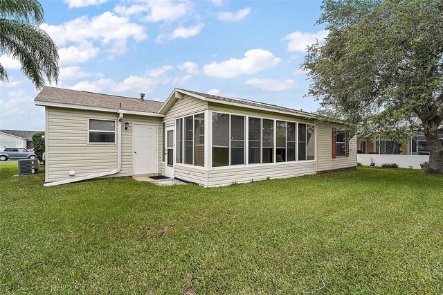 2788 Privada Dr, The Villages, FL 32162 - rear view of house featuring a sunroom, a yard, and central air condition unit