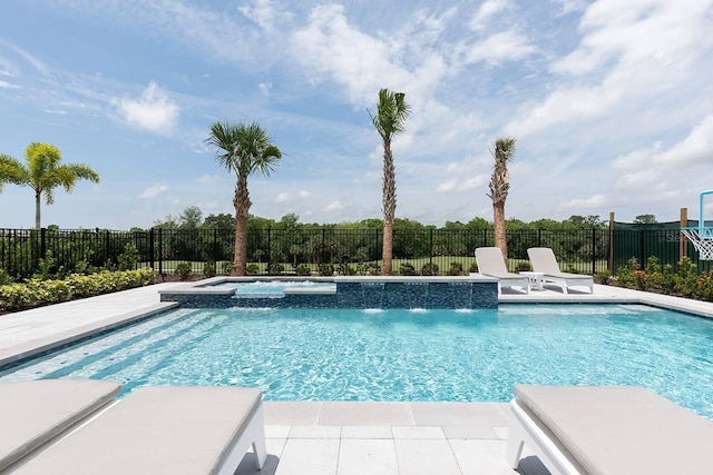 view of swimming pool featuring a patio area, pool water feature, and an in ground hot tub