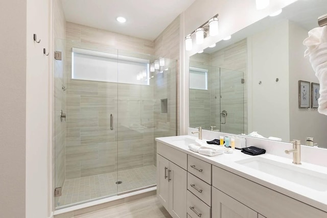 bathroom featuring vanity, hardwood / wood-style flooring, and a shower with shower door