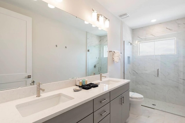 bathroom with toilet, vanity, and a shower with door