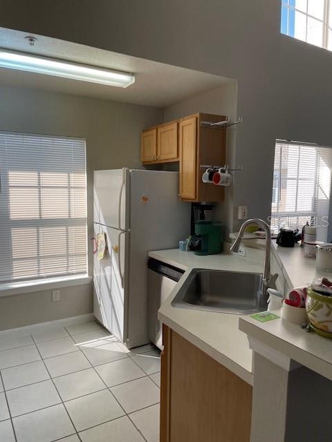 kitchen featuring sink, light tile patterned flooring, and stainless steel dishwasher