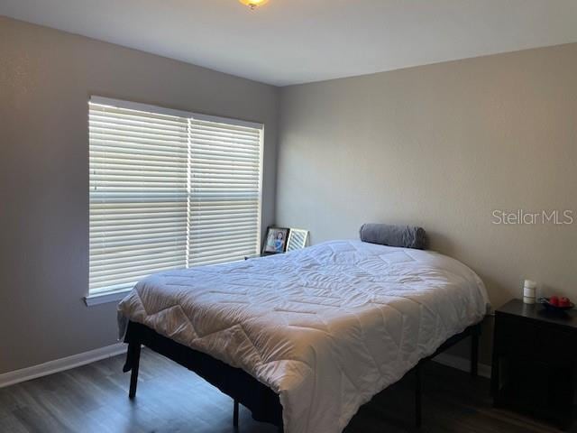 bedroom with dark hardwood / wood-style flooring