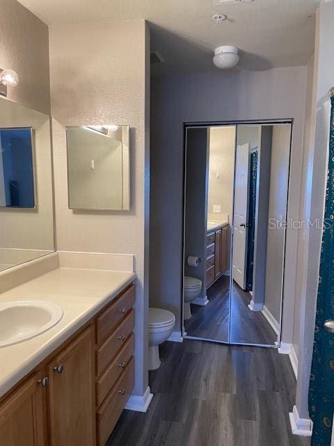 bathroom featuring hardwood / wood-style floors, vanity, and toilet