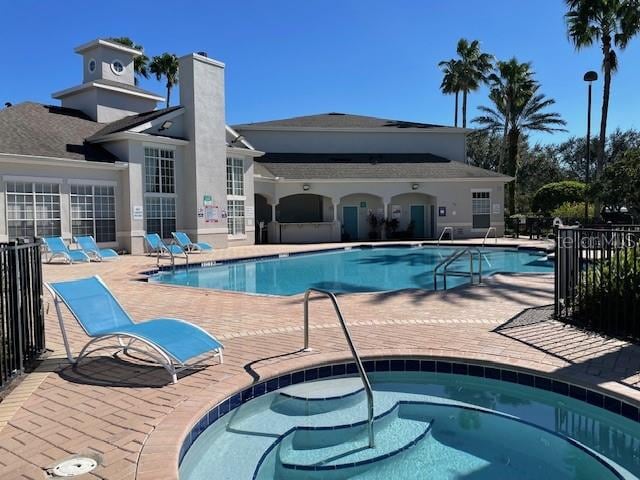 view of swimming pool featuring a patio area and a community hot tub