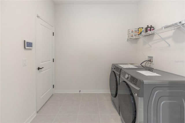 laundry area featuring separate washer and dryer and light tile patterned flooring