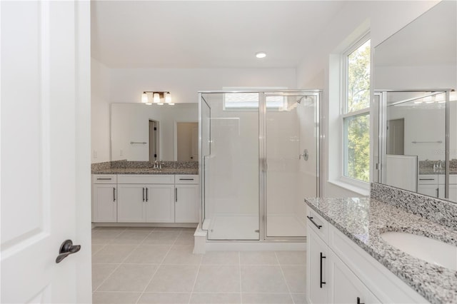 bathroom with tile patterned flooring, a healthy amount of sunlight, and a shower with door