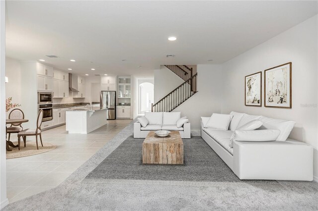 living room with light tile patterned floors, stairway, arched walkways, and recessed lighting