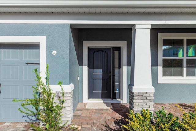 5648 Green Arrow Pl, Sanford, FL 32773 - view of exterior entry featuring stucco siding and a garage