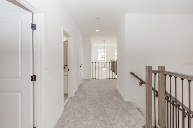 5648 Green Arrow Pl, Sanford, FL 32773 - hall featuring an upstairs landing, light colored carpet, baseboards, and a chandelier